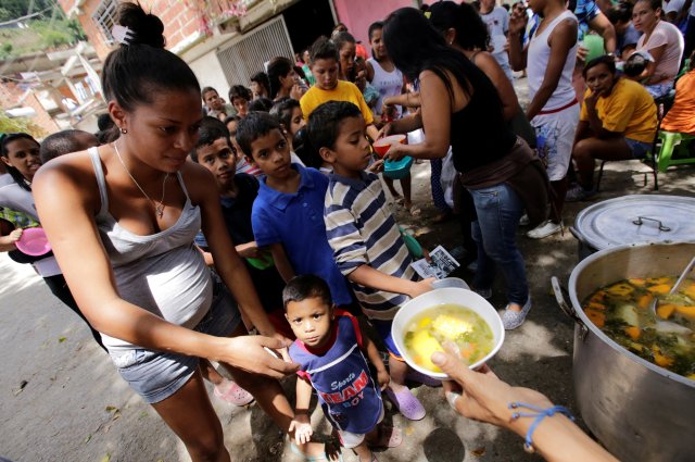 Children queue as they wait to receive free food which was prepared by residents and volunteers on a street in the low-income neighborhood of Caucaguita in Caracas, Venezuela September 17, 2016. REUTERS/Henry Romero