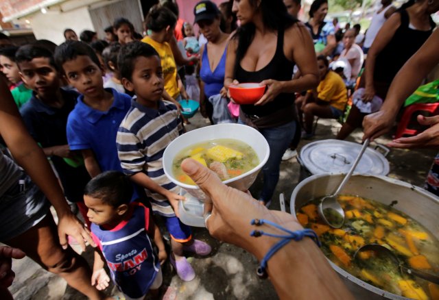 Children queue wait to receive free food which was prepared by residents and volunteers on a street in the low-income neighborhood of Caucaguita in Caracas, Venezuela September 17, 2016. REUTERS/Henry Romero