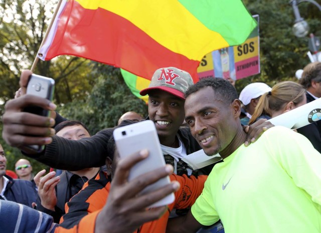 Supporters make selfies with the winner Kenenisa Bekele (R) of Ethiopia after the finish at the Berlin marathon in Berlin, Germany, September 25, 2016. REUTERS/Fabrizio Bensch