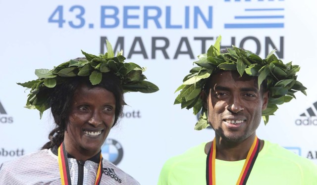 Winners Kenenisa Bekele (R) of Ethiopia and Aberu Kebede of Ethiopia celebrate during the victory ceremony at the Berlin marathon in Berlin, Germany, September 25, 2016. REUTERS/Fabrizio Bensch