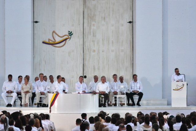 The leader of the FARC, Rodrigo Londono (R) -- better known by his nom de guerre, Timoleon "Timochenko" Jimenez delivers a speech after signing the historic peace agreement between the Colombian government and the Revolutionary Armed Forces of Colombia (FARC), in Cartagena, Colombia, on September 26, 2016 The Colombian government and the leftist FARC rebel force signed a historic peace accord to end a half-century conflict that has killed hundreds of thousands of people. Santos and "Timochenko" Jimenez, signed the deal at a ceremony in the Caribbean city of Cartagena, prompting loud cheers from the crowd which included numerous international dignitaries. / AFP PHOTO / Luis ACOSTA