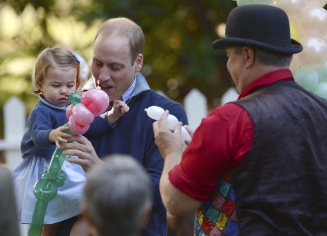 Britain's Prince William holds Princess Charlotte as she is given a balloon animal during a children's tea party at Government House in Victoria, British Columbia, Canada September 29, 2016.  REUTERS/Jonathan Hayward/Pool