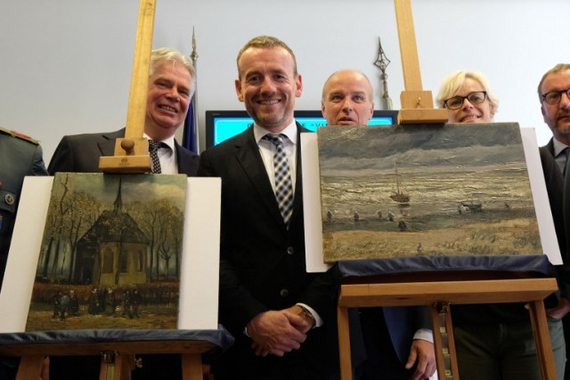Axel Ruger, Director of the Van Gogh museum poses next to Congregation Leaving the Reformed Church in Nuenen" (L) and "The Beach At Scheveningen During A Storm" (R) by Vincent van Gogh, two Van Gogh paintings stolen in Amsterdam 14 years ago and recently recovered by organised crime investigators in Italy, on September 30, 2016. / AFP PHOTO / MARIO LAPORTA