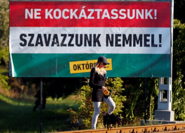 Una apabullante mayoría de húngaros previsiblemente rechazará las cuotas de inmigración de la Unión Europea en un referéndum el domingo, lo que debería dar un impulso al primer ministro Viktor Orban en casa y reforzarlo en sus pugnas con Bruselas. En la imagen, una mujer camina con su perro junto a un cartel del Gobierno húngaro sobre el referéndum que dice "No deberíamos asumir riesgos, vota no", en Budapest, el 30 de septiembre de 2016. REUTERS/Laszlo Balogh
