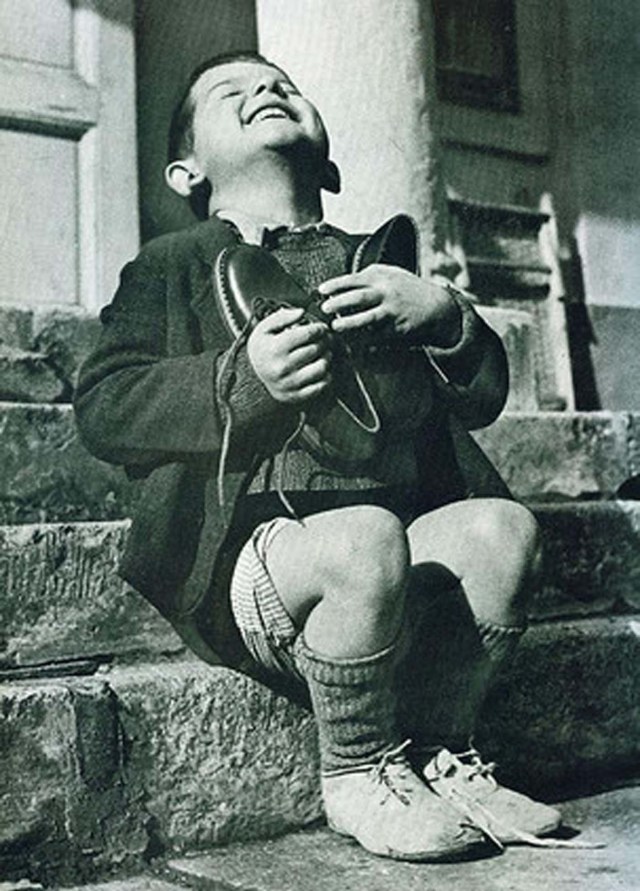 Un niño austríaco es feliz tras recibir zapatos nuevos durante la Segunda Guerra Mundial.