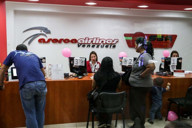 ACOMPAÑA CRÓNICA: VENEZUELA AEROLÍNEAS CAR205. CARACAS (VENEZUELA), 20/10/2016.- Fotografía de personas a una oficina de la aerolínea venezolana Aserca hoy, jueves 20 de octubre de 2016, en Caracas (Venezuela). La merma de aerolíneas, de frecuencias y de asientos obliga a los venezolanos a sortear cada vez mayores obstáculos para hacerse con un boleto aéreo internacional, la mayoría de ellos solo abonables en moneda extranjera, en medio de la crisis que aqueja al país caribeño. EFE/CRISTIAN HERNÁNDEZ