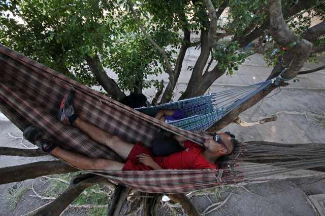 ACOMPAÑA CRÓNICA: BRASIL VENEZUELA BRA08. BOA VISTA (BRASIL), 22/10/2016.- Los venezolanos José Antonio Garrido (d) y Sairelis Ríos (i) duermen en sus hamacas este jueves, 20 de octubre de 2016, frente a la terminal de autobuses de Boa Vista, estado de Roraima (Brasil). Es venezolana, tiene 20 años, quiere ser traductora y hoy, en una hamaca colgada en un árbol que ha convertido en su casa en la ciudad brasileña de Boa Vista, mece unos sueños que, según aseguró, no serán truncados por "el fracaso de una revolución". "No estoy aquí por política. Lo que me trajo aquí fue el fracaso de unas políticas", dijo a Efe Sairelis Ríos, quien junto a su madre Keila y una decena de venezolanos vive en plena calle, frente a la terminal de autobuses de Boa Vista, una ciudad que en los últimos meses ha recibido unos 2.500 emigrantes de ese país vecino. EFE/Marcelo Sayão