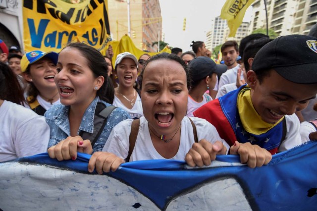 University students march against the government of Venezuelan President Nicolas Maduro in the streets of Caracas on October 26, 2016. Venezuela's political rivals are set to engage in a volatile test of strength on Wednesday, with the opposition vowing mass street protests as President Nicolas Maduro resists efforts to drive him from power. The socialist president and center-right-dominated opposition accuse each other of mounting a "coup" in a volatile country rich in oil but short of food. / AFP PHOTO / Juan BARRETO