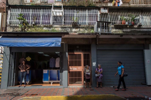 CAR01. CARACAS (VENEZUELA), 28/10/2016.- Un local comercial abierto y otro cerrado vistos hoy, viernes 28 de octubre de 2016, en Caracas (Venezuela). El paro general de 12 horas convocado por la oposición venezolana se cumple a medias en el país pues tanto las entidades bancarias como algunos comercios y oficinas abrieron sus puertas, sin embargo, las principales vías se mostraron con mucho menos tráfico que el que se observa en un día laboral normal. EFE/MIGUEL GUTIÈRREZ