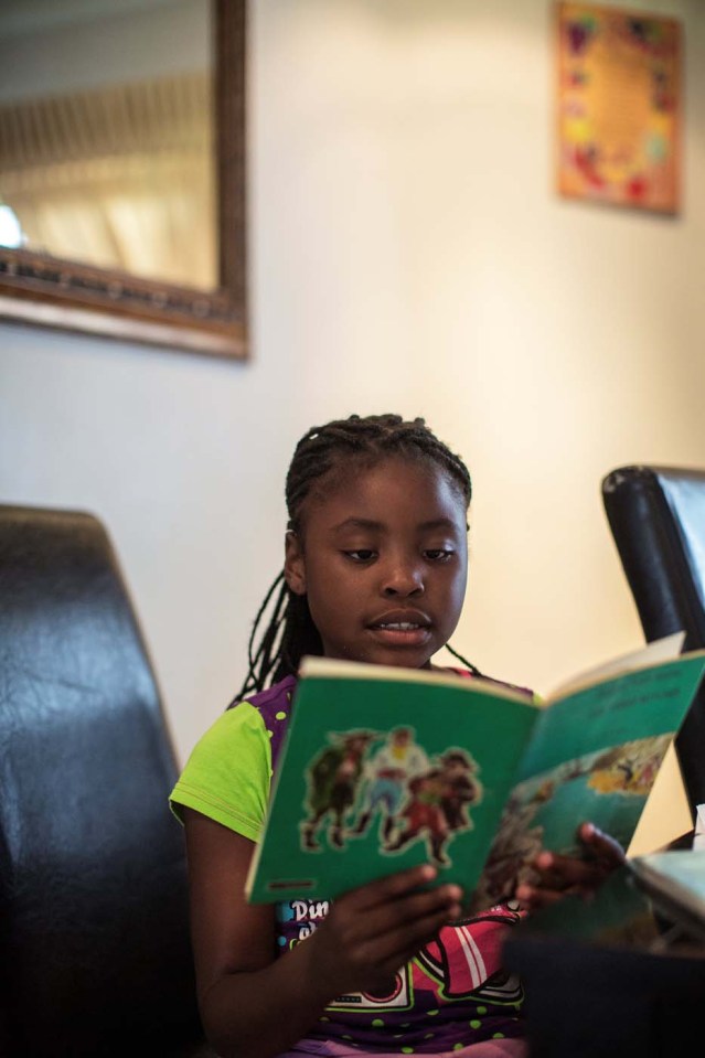 Seven-year-old author Michelle Nkamankeng looks at her homework at her house on October 26, 2016 in Johannesburg, South Africa.  Michelle Nkamankeng has made history by being the youngest author from the African continent to make it in the top 10 youngest writers in the world.  / AFP PHOTO / GIANLUIGI GUERCIA