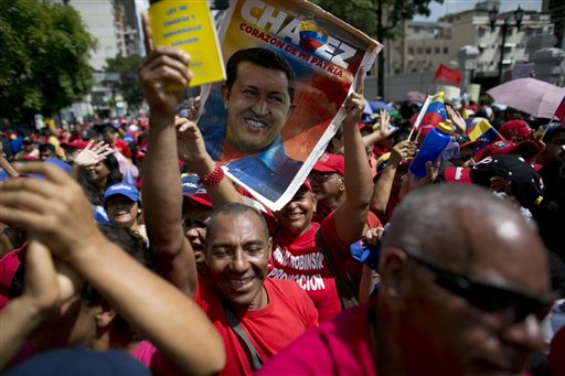 En esta imagen del 28 de octubre de 2016, un partidario del gobierno sostiene un cartel con la imagen del fallecido presidente de Venezuela Hugo Chávez durante un mitin en apoyo del presidente, Nicolás Maduro, ante el palacio presidencial de Caracas, Venezuela. (AP Foto/Ariana Cubillos)