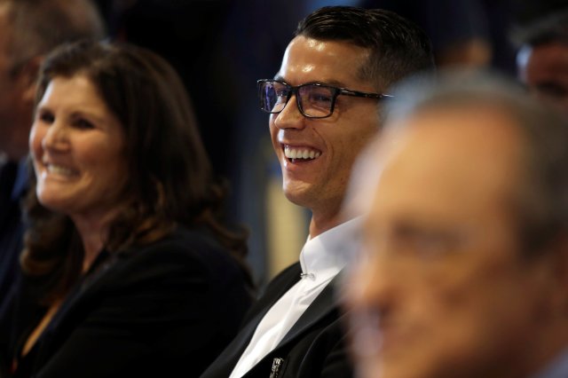 Real Madrid's Cristiano Ronaldo (C) smiles next to his mother Dolores Aveiro and the club's president Florentino Perez during a ceremony for Ronaldo's contract renewal at Santiago Bernabeu stadium in Madrid, Spain, November 7, 2016. REUTERS/Susana Vera
