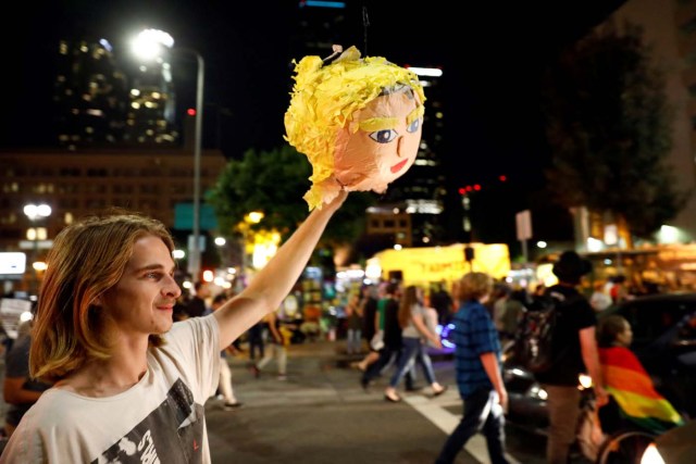 A demonstrator holds a pinata head of Donald Trump through the streets of downtown Los Angeles in protest following the election of Republican Donald Trump as President of the United States in Los Angeles, California November 10, 2016. REUTERS/Patrick T. Fallon