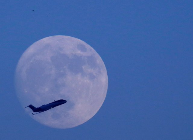 A plane flies past the moon a day before the "supermoon" spectacle in Kathmandu, Nepal November 13, 2016. REUTERS/Navesh Chitrakar