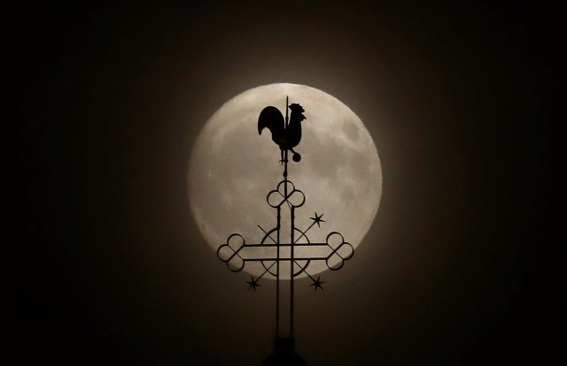The weathercock of the church of St.Peter and Paul is seen in front of a moon on the eve of the "supermoon" spectacle in the village of Klein-Auheim near Hanau, Germany, early evening November 13, 2016. REUTERS/Kai Pfaffenbach TPX IMAGES OF THE DAY