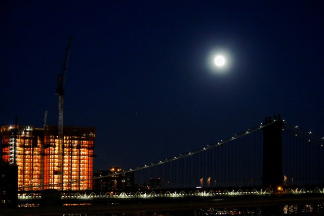 A full moon is seen over the Manhattan Bridge during the eve of the "supermoon" in New York, U.S. November 13, 2016. REUTERS/Eduardo Munoz