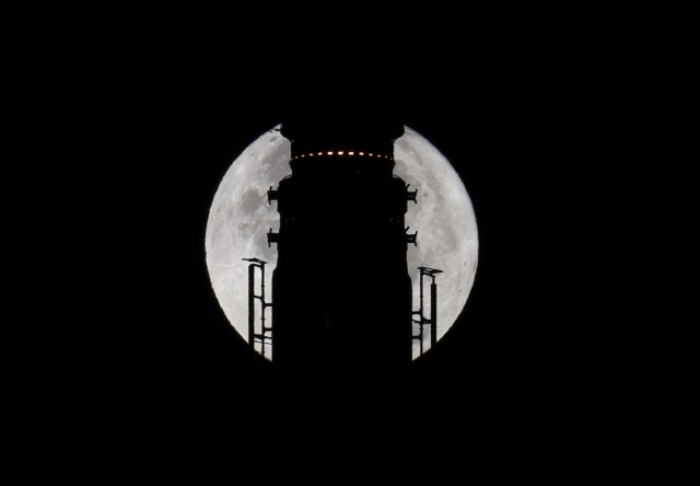 The Supermoon goes down behind the spire of the Empire State Building the morning of November 14, 2016 in New York. Skygazers took to high-rise buildings, observatories and beaches Monday to get a glimpse of the closest "supermoon" to Earth in almost seven decades, and snap dramatic pictures. The phenomenon happens when the moon is full at the same time as, or very near, perigee -- its closest point to Earth on an elliptical, monthly orbit. / AFP PHOTO / DON EMMERT