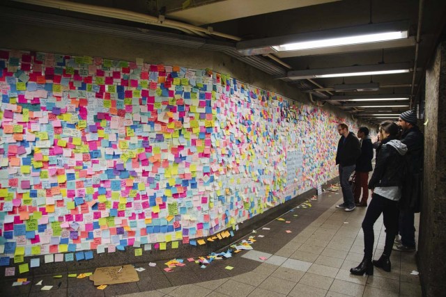 AVX11 NUEVA YORK (ESTADOS UNIDOS) 13/11/2016.- Varios ciudadanos observan las notitas de colores que cubren un muro y que forman parte de la pieza artística "Subway Therapy" en la estación de metro de Union Square en Manhattan, Nueva York (Estados Unidos) hoy, 13 de noviembre de 2016. El número de post-it de la obra, que inició el artista estadounidense Matthew Chavez el 10 de noviembre, continúa creciendo mientras los ciudadanos siguen añadiendo nuevas notas. EFE/Alba Vigaray