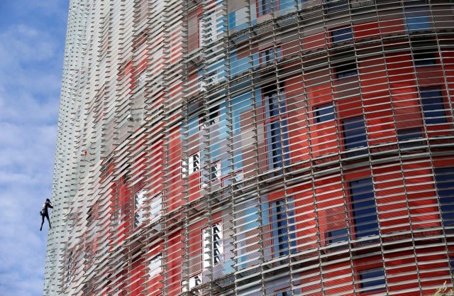 French climber Alain Robert, also known as "The French Spiderman", scales the 38-story skyscraper Torre Agbar in Barcelona, Spain, November 25, 2016. REUTERS/Albert Gea