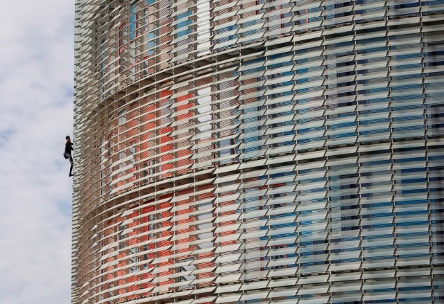 French climber Alain Robert, also known as "The French Spiderman", scales the 38-story skyscraper Torre Agbar in Barcelona, Spain, November 25, 2016. REUTERS/Albert Gea