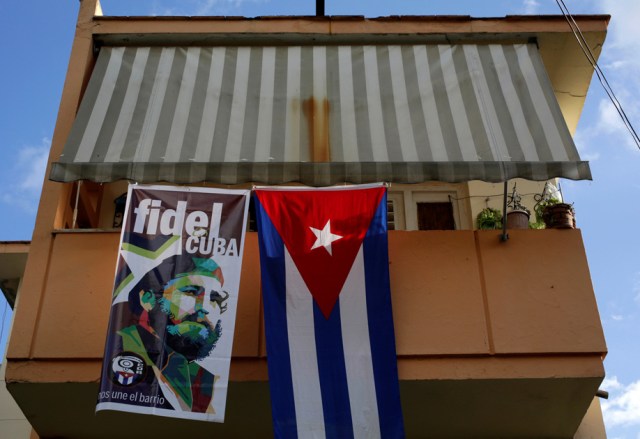 A banner with an image of Cuba's former president Fidel Castro hang on the balcony of a house near a Cuban flag in Havana, Cuba November 27, 2016. REUTERS/Enrique de la Osa