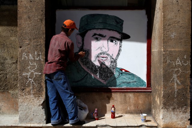 A local artist paints a portrait of Fidel Castro in front of a shop in downtown Havana, following the announcement of the death of the Cuban revolutionary leader, in Cuba