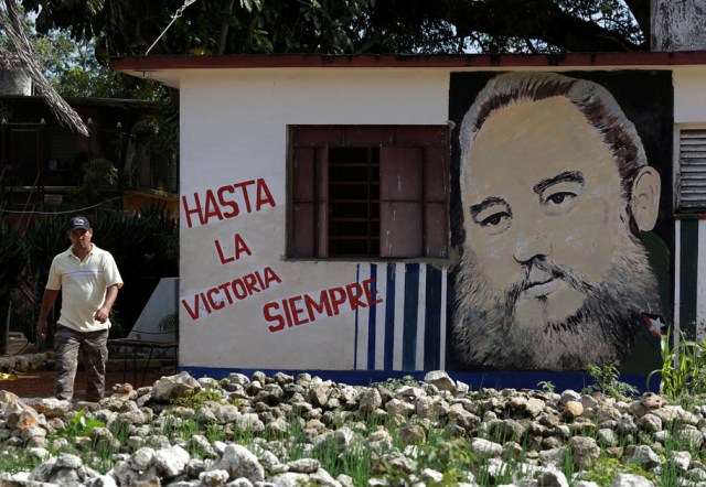 A man walks near a garaffiti of Cuba's former president Fidel Castro in Artemisa province, Cuba November 27, 2016. The words on the wall read, "Ever onward, to victory". REUTERS/Enrique de la Osa