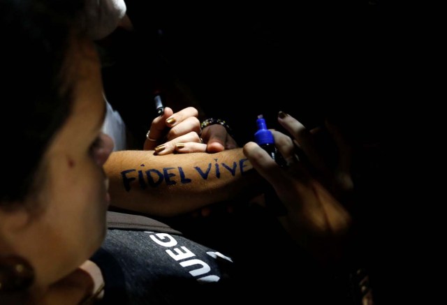 A woman writes "Fidel lives" on her forearm during a massive tribute to Cuba's late President Fidel Castro on Revolution Square in Havana, Cuba, November 29, 2016. REUTERS/Stringer EDITORIAL USE ONLY. NO RESALES. NO ARCHIVE