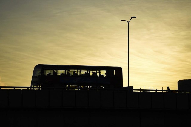 A double decker bus carries commuters as they make their way across London Bridge as the sun rises over London, Britain November 30, 2016. REUTERS/Dylan Martinez