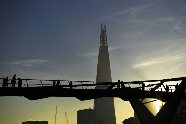 The Shard is seen as commuters make their way across the Millennium Bridge as the sun rises over London, Britain November 30, 2016. REUTERS/Dylan Martinez