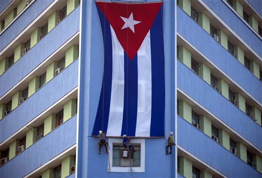 Trabajadores cuelgan una bandera cubana gigante en un edificio del gobierno en La Habana, Cuba, el domingo 27 de noviembre de 2016, dos días después de la muerte de Fidel Castro. Cuba está atravesando por nueve días de duelo por el expresidente, que dirigió el país por medio siglo. (AP Foto, Desmond Boylan)