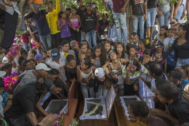 En esta imagen, tomada el 13 de noviembre de 2016, parientes de nueve hombres de una familia de pescadores, que recibieron un disparo en la cabeza cuando estaban arrodillados, lloran su muerte en el cementerio de Cariaco, en el estado de Sucre, Venezuela. Cinco agentes fueron acusados de irrumpir en la localidad y matar a los hombres, de una familia de pescadores, que se creía que pertenecían a una banda. (AP Foto/Rodrigo Abd)