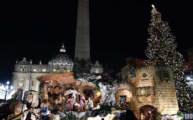 The Christmas tree (R) and the nativity scene (C) are pictured at the Saint Peter's square following the illumination ceremony on December 9, 2016 in Vatican. This year, the Christmas ornaments were made by children of the paediatric oncology departments of Italian hospitals. / AFP PHOTO / VINCENZO PINTO
