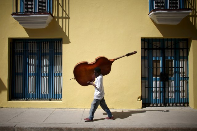 FILE PHOTO - Musician Frilal Ortiz carries a double bass in downtown Havana, March 16, 2016. REUTERS/Alexandre Meneghini/File Photo REUTERS PICTURES OF THE YEAR 2016 - SEARCH 'POY 2016' TO FIND ALL IMAGES
