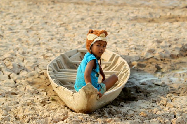 FILE PHOTO - A girl sits on her boat at a Bak Angrout dried up pond at the drought-hit Kandal province in Cambodia May 13, 2016. REUTERS/Samrang Pring/File Photo REUTERS PICTURES OF THE YEAR 2016 - SEARCH 'POY 2016' TO FIND ALL IMAGES