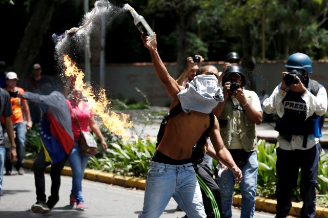 FILE PHOTO - A demonstrator throws a molotov cocktail against riot policemen during a protest called by university students against Venezuela's government in Caracas, Venezuela, June 9, 2016. REUTERS/Carlos Garcia Rawlins/File Photo REUTERS PICTURES OF THE YEAR 2016 - SEARCH 'POY 2016' TO FIND ALL IMAGES