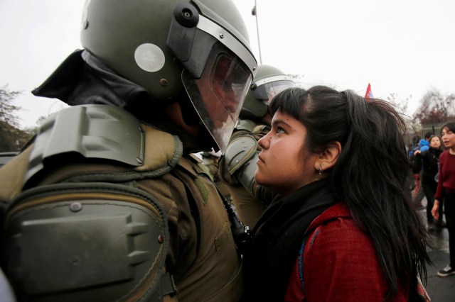 FILE PHOTO - A demonstrator looks at a riot policeman during a protest marking the country's 1973 military coup in Santiago, Chile September 11, 2016. REUTERS/Carlos Vera/File Photo REUTERS PICTURES OF THE YEAR 2016 - SEARCH 'POY 2016' TO FIND ALL IMAGES