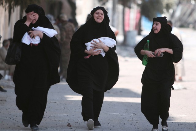 FILE PHOTO - Women carry newborn babies while reacting after they were evacuated by the Syria Democratic Forces (SDF) fighters from an Islamic State-controlled neighbourhood of Manbij, in Aleppo Governorate, Syria, August 12, 2016. REUTERS/Rodi Said/File Photo REUTERS PICTURES OF THE YEAR 2016 - SEARCH 'POY 2016' TO FIND ALL IMAGES