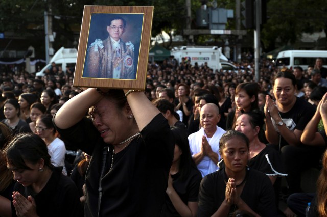 FILE PHOTO - A woman cries while holding up a portrait of Thailand's King Bhumibol Adulyadej while his body is being moved from the Bangkok hospital where he died to the Grand Palace, in Bangkok, Thailand, October 14, 2016. REUTERS/Athit Perawongmetha/File Photo REUTERS PICTURES OF THE YEAR 2016 - SEARCH 'POY 2016' TO FIND ALL IMAGES