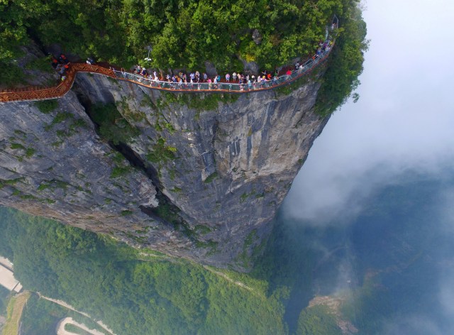 FILE PHOTO - People walk on a sightseeing platform in Zhangjiajie, Hunan Province, China, August 1, 2016. REUTERS/Stringer/File Photo ATTENTION EDITORS - THIS IMAGE WAS PROVIDED BY A THIRD PARTY. EDITORIAL USE ONLY. CHINA OUT. NO COMMERCIAL OR EDITORIAL SALES IN CHINA. REUTERS PICTURES OF THE YEAR 2016 - SEARCH 'POY 2016' TO FIND ALL IMAGES