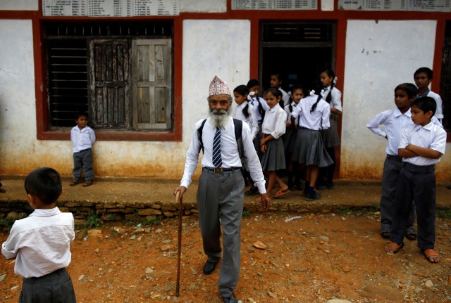 FILE PHOTO - Durga Kami, 68, who is studying in the tenth grade at Shree Kala Bhairab Higher Secondary School, walks outside the school in Syangja, Nepal, June 5, 2016. REUTERS/Navesh Chitrakar/File Photo REUTERS PICTURES OF THE YEAR 2016 - SEARCH 'POY 2016' TO FIND ALL IMAGES