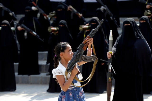 FILE PHOTO - A girl holds a rifle in front of women loyal to the Houthi movement taking part in a parade to show support to the movement in Sanaa, Yemen September 6, 2016. REUTERS/Khaled Abdullah/File Photo REUTERS PICTURES OF THE YEAR 2016 - SEARCH 'POY 2016' TO FIND ALL IMAGES