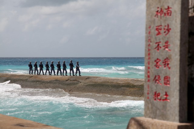 FILE PHOTO - Soldiers of China's People's Liberation Army (PLA) Navy patrol near a sign in the Spratly Islands, known in China as the Nansha Islands, February 9, 2016. The sign reads 'Nansha is our national land, sacred and inviolable.' REUTERS/Stringer/File Photo ATTENTION EDITORS - THIS PICTURE WAS PROVIDED BY A THIRD PARTY. THIS PICTURE IS DISTRIBUTED EXACTLY AS RECEIVED BY REUTERS, AS A SERVICE TO CLIENTS. CHINA OUT. NO COMMERCIAL OR EDITORIAL SALES IN CHINA REUTERS PICTURES OF THE YEAR 2016 - SEARCH 'POY 2016' TO FIND ALL IMAGES