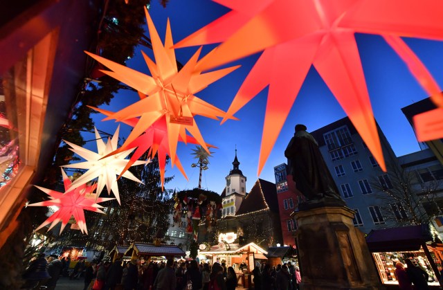 Illuminated Christmas stars hang from a booth of the Christmas Market in Jena, eastern Germany, on December 5, 2016. / AFP PHOTO / dpa / Martin Schutt / Germany OUT