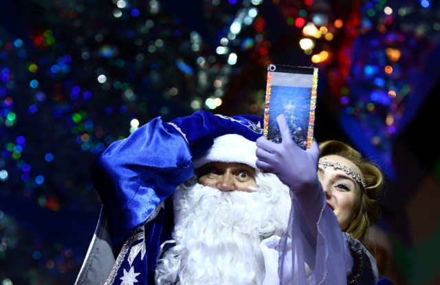 People dressed as Father Frost, the equivalent of Santa Claus, and Snow Maiden take a selfie as they take part in the contest "Yolka-fest-2016" (Fir-festival-2016) in Minsk, Belarus December 9, 2016. REUTERS/Vasily Fedosenko