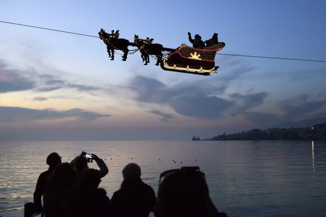 LG200 MONTREUX (SUIZA), 06/12/2016.- Una instalación que representa una figura de Papá Noel sobre un trineo tirado por renos, permanece suspendida por un cable sobre el lago de Ginebra en Montreaux, Suiza, hoy, 6 de diciembre de 2016. EFE/LAURENT GILLIERON