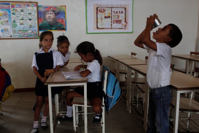 En esta foto del 8 de noviembre de 2016, un niño se termina su desayuno en el salón de una escuela pública de Punta de Araya, estado de Sucre, Venezuela. Los horarios de estudio se determinan según la disponibilidad de comida para los estudiantes y muchas veces las clases se suspenden debido a la falta de agua potable. (AP Foto/Rodrigo Abd)