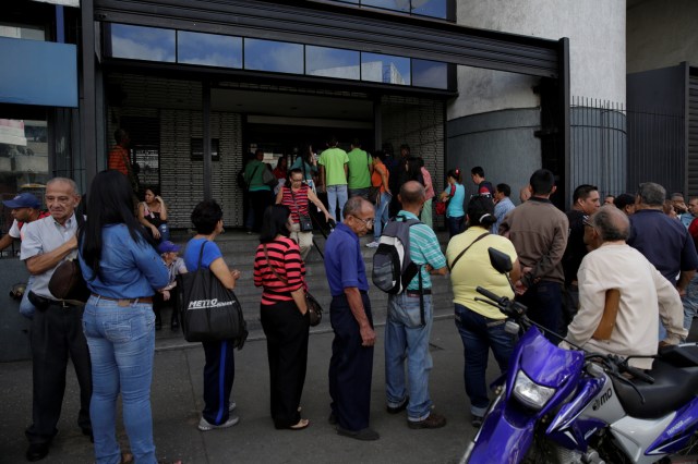 People line up to get into a Banco Mercantil branch in Caracas, Venezuela December 13, 2016. REUTERS/Marco Bello