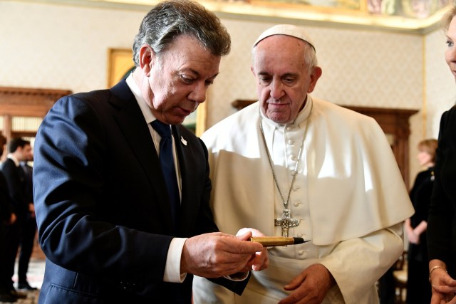 Pope Francis (R) receives "The pencil of the peace" from Colombia's President Juan Manuel Santos (L) during a meeting at the Vatican December 16, 2016. REUTERS/Vincenzo Pinto/Pool