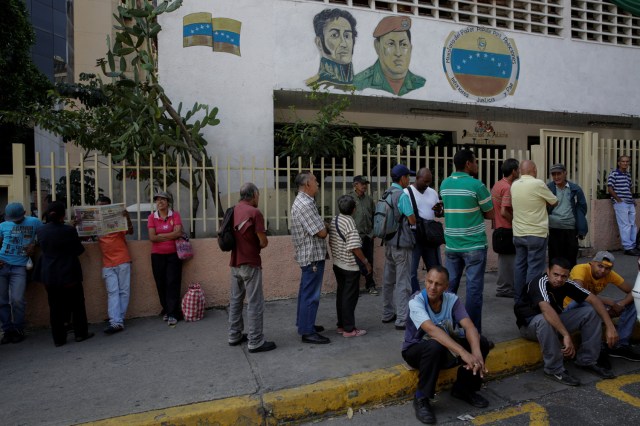 People queue to deposit their 100 bolivar notes near Venezuela's Central Bank in Caracas, Venezuela December 16, 2016. REUTERS/Marco Bello